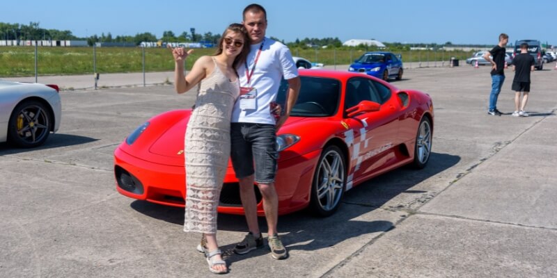 para przy czerwonym ferrari f430 na torze wyścigowym