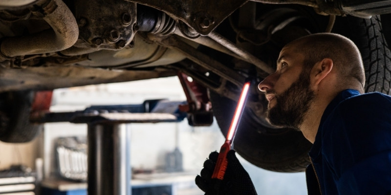 mechanik oglądający auto  od spodu