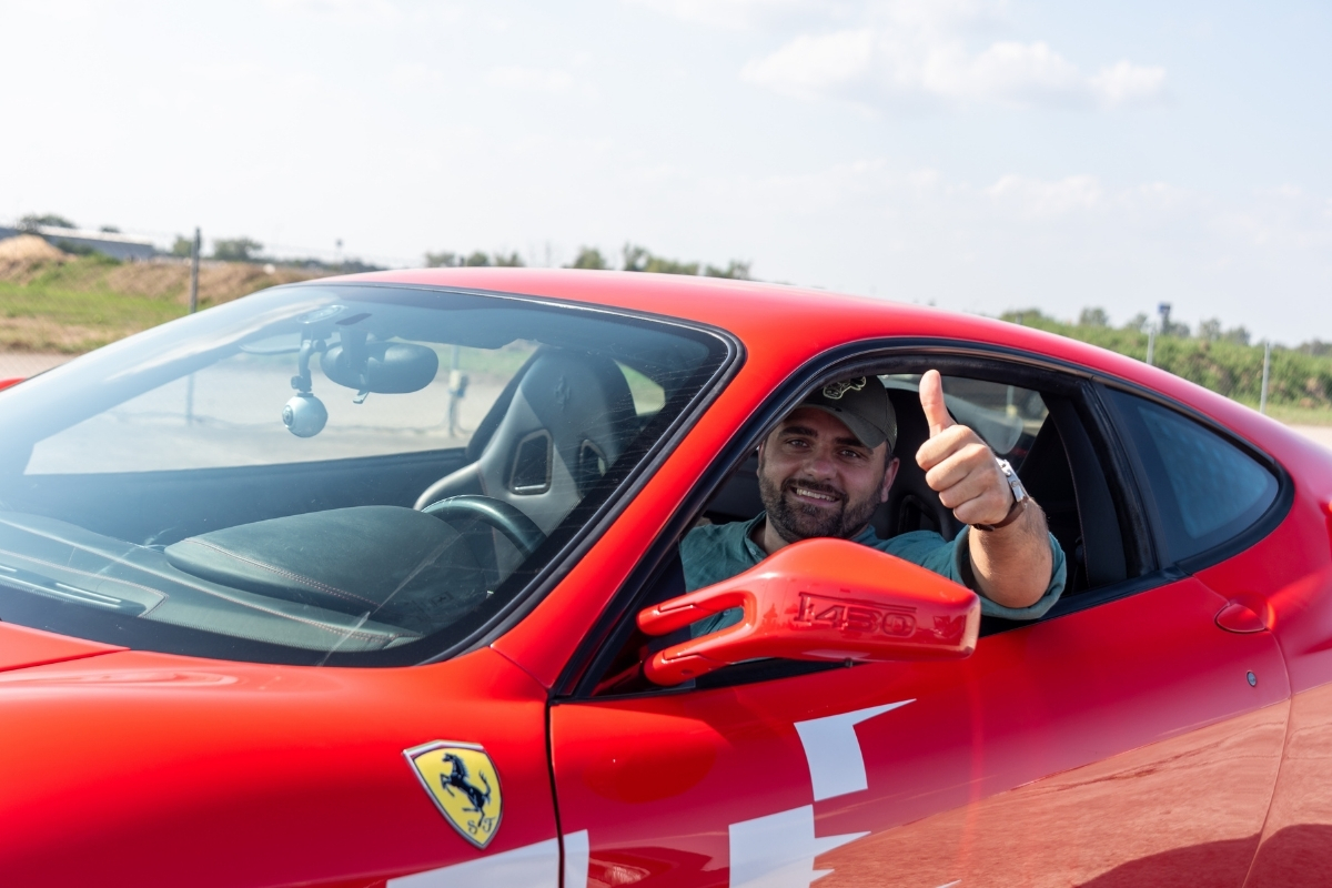 mężczyzna w ferrari f430 z kamerą do nagrywania jazdy